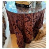 Round glass top table with custom silk cover.