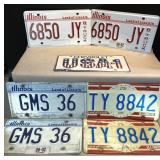 7 license plates, 1 is Red, white and blue,
