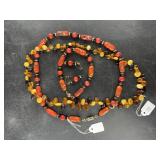 A beaded amber necklace and an artisan glass bead
