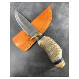 Damascus bladed knife with large sheep horn handle
