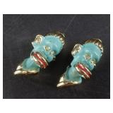 A pair of pins, glass and enamel depicting a figur