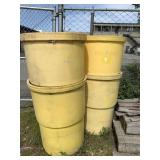 Four large yellow plastic barrels