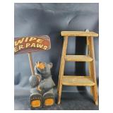 Bear holding a "Welcome" sign and a small step lad