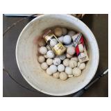 Bucket of golf balls and putters