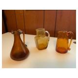 Three Amber-Toned Glass Pitchers