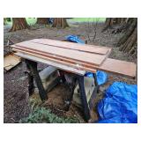 Hardwood boards, saw horses, tarp, and cinder