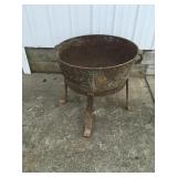 Large cast-iron pot turned into a flower pot has