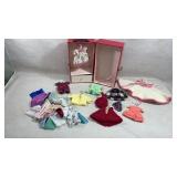 collection of vintage doll clothes and a carry