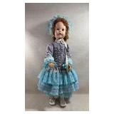 large doll in an elaborate dress and bonnet