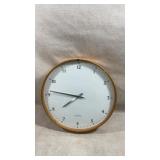 minimalist analog wall clock featuring a warm