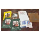 collection of assorted artist paper pads, canvas