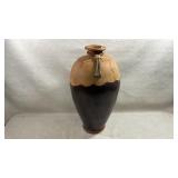 rustic earthenware vase features a distinctive