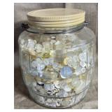 Glass jar filled with mixed white buttons