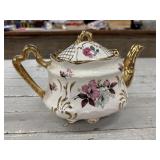 Vintage porcelain teapot featuring a white base