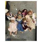 A tote full of larger porcelain baby dolls