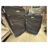 2 black Milano brand suitcases.