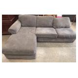Grey upholstered sectional with lounge built