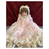 Vintage porcelain collector doll in pink dress.