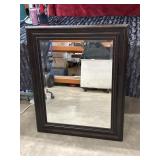 Large rectangular wall mirror features a dark