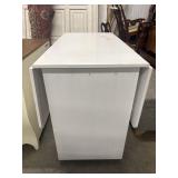 White dining table with drop leafs sides.