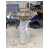 Concrete bird bath features a squirrel climbing