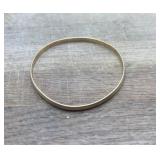 Thin, yellow gold bangle bracelet features subtle