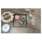 A "Welcome" wreath and various metal floral wall