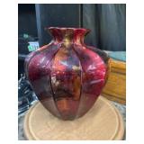 Striking decorative vase features a vibrant red