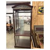 Dark wood lighted curio display cabinet.