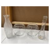 Assorted clear glass vases feature a mix of round