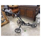 A Qwik-Fold collapsible golf push cart.