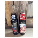 2 Vintage commemorative Coca-Cola bottles: one on