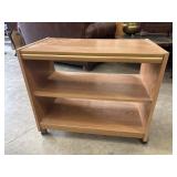 Compact wooden storage shelf on wheels with a