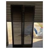 2 tall, dark brown wooden louvered shutters with