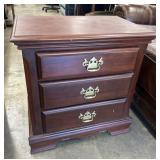 Traditional three-drawer wooden nightstand in a