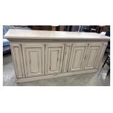 Distressed cream-painted wooden credenza with