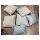 6 Decorative throw pillows in shades of ivory,