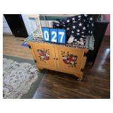 small apple painted cupboard and what is on it
