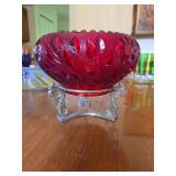 vintage ruby red pressed glass bowl with an embossed leaf and floral pattern, resting on a decorative silver-tone or metal tripod stand