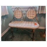 Vintage metal scrollwork settee featuring a long tufted seat and two matching round back cushions in a warm bronze finish