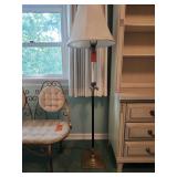 Traditional floor lamp with a brown and bronze-finish metal body, a faux-candle detail with leaf accents, and an off-white fabric empire lampshade.