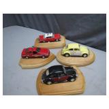 Four Diecast Cars on Wooden Stands