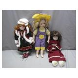 Three Porcelain Dolls in Varied Outfits
