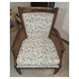 wood armchair with cane side panels and a floral