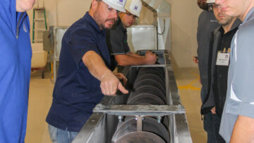 Examining a screw conveyor.