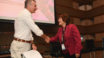 Karen Plaut, Purdue executive vice president for research [right], shakes hands with Robert Reiter, Bayer head of crop science research and development, after signing an agreement Sept. 19 in St. Louis, MO creating the Coalition for Sustainable and Regenerative Agriculture. (Photo courtesy of Bayer)