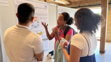 Researchers discuss a scientific poster at the 2023 Soil and Water Assessment Tool conference in Denmark.