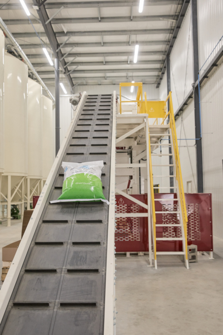 Tracker belt feed to palletizing and wrapping.