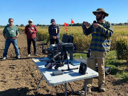 Josh Hegarty, of the UC Davis Department of Plant Sciences, uses a drone equipped with an RBG camera to collect data on small test plots of grains. (Trina Kleist/UC Davis)