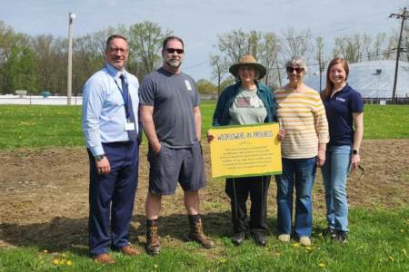 Project collaborators hold educational sign in front of native planting. From left to right: Craig Palmer, Erie Water Works; Greg Kedzierski, Ernst Conservation Seeds; Freda Tepfer, community member; Jean Ganger, Master Watershed Steward; Amber Stilwell, Penn State Extension. (Photo credit: Gary Rihn, Master Watershed Steward)